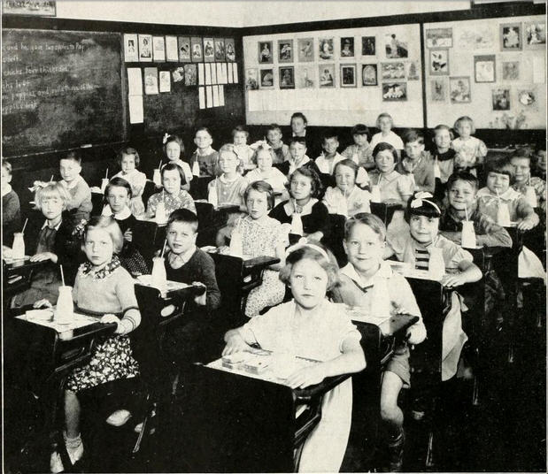 a classroom filled with students and children working on drawings