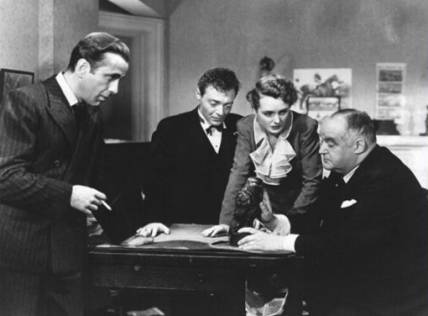 a black and white image of five people at a desk
