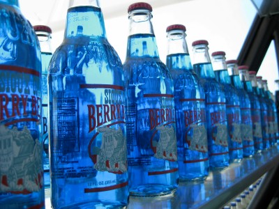 large blue bottles of beer are lined up