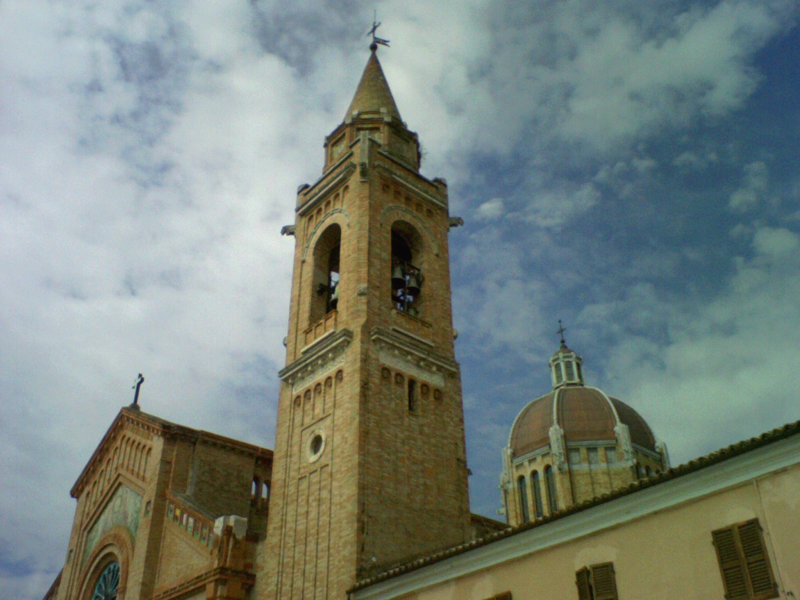 a tall stone clock tower under a cloudy blue sky