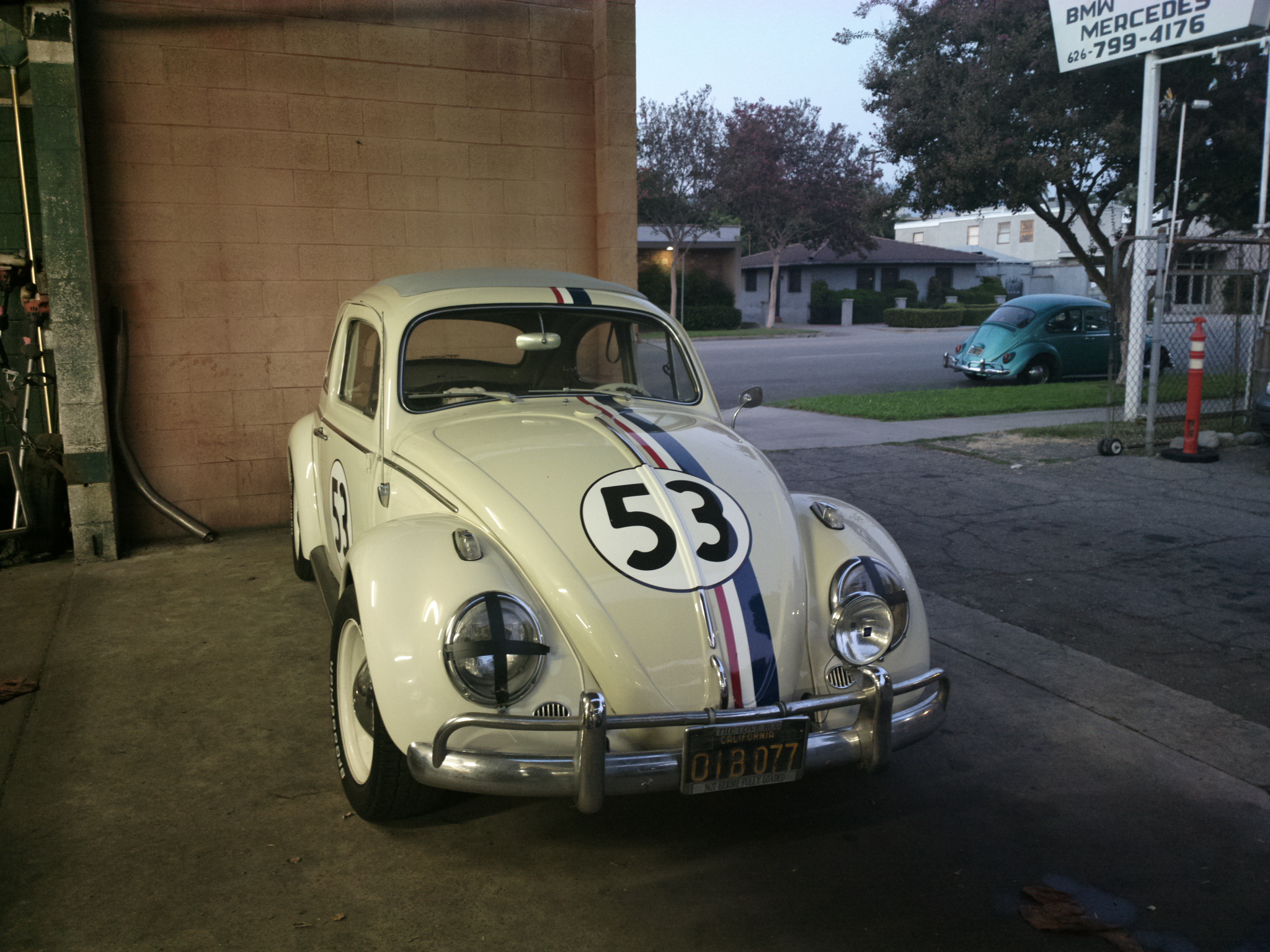 a vintage vw beetle sits in a garage