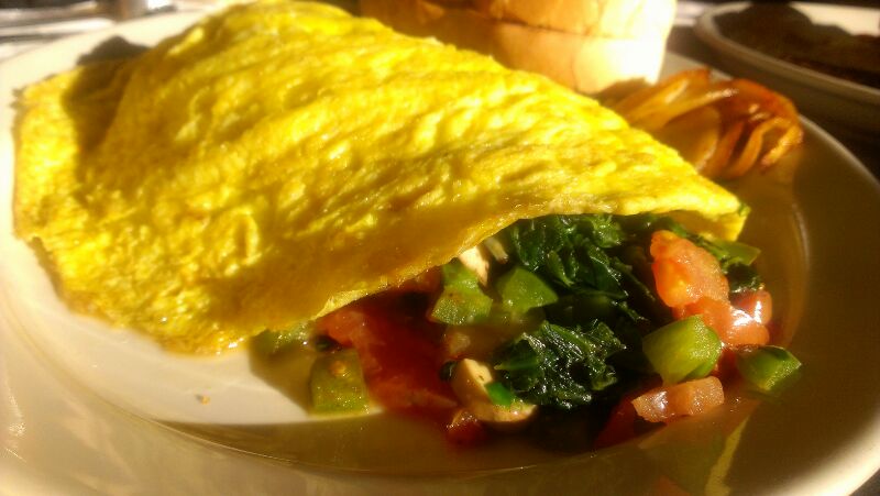 a omelet with vegetables and meat on a white plate