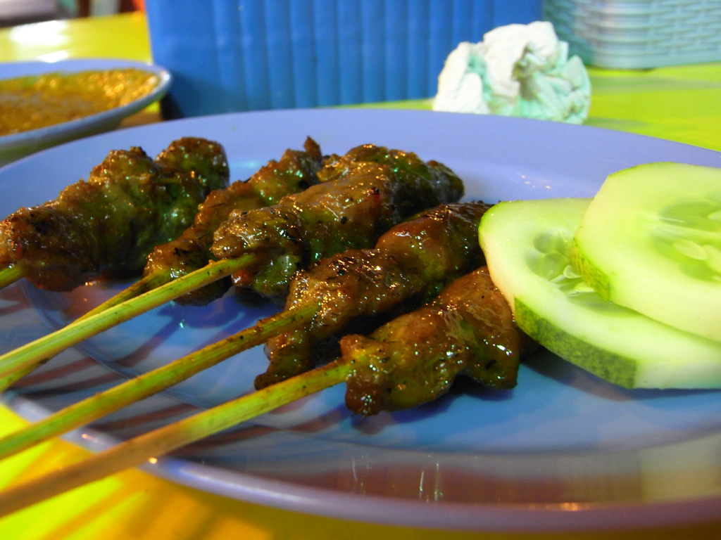 a plate full of chicken and cucumber skewers