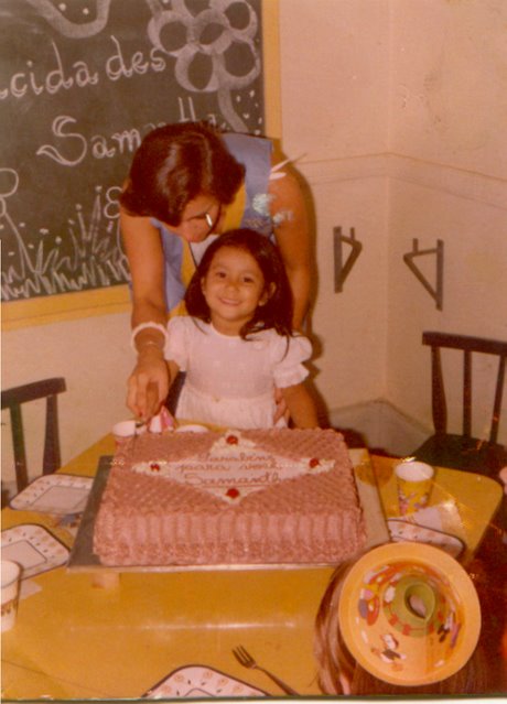 a woman and a little girl  into a large pink cake