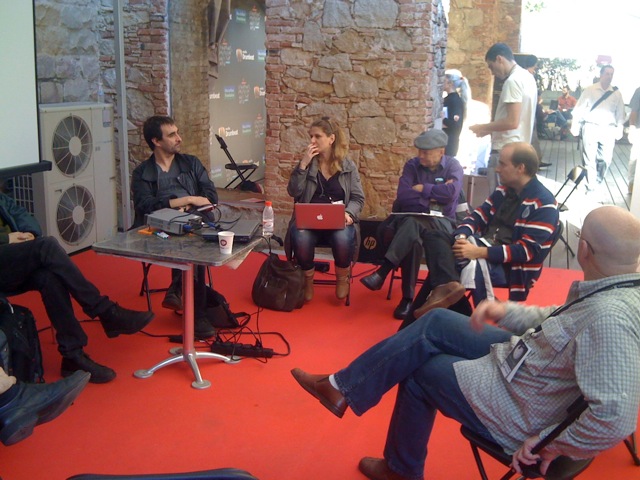 group of people sitting at small tables on a carpet in an open area