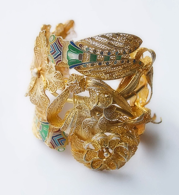 gold celets with green and yellow flowers on them
