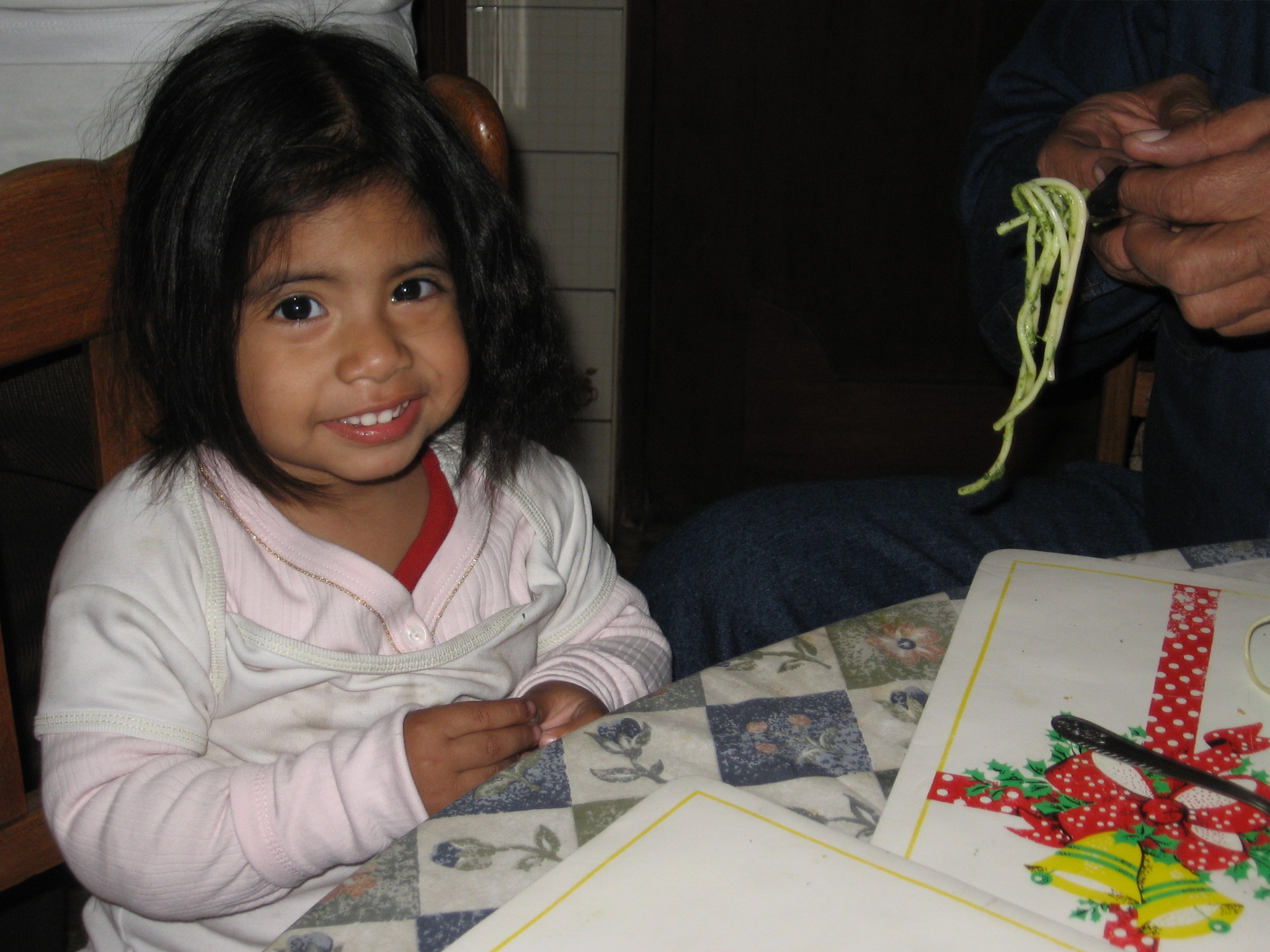 a young child holding a string while sitting at a table