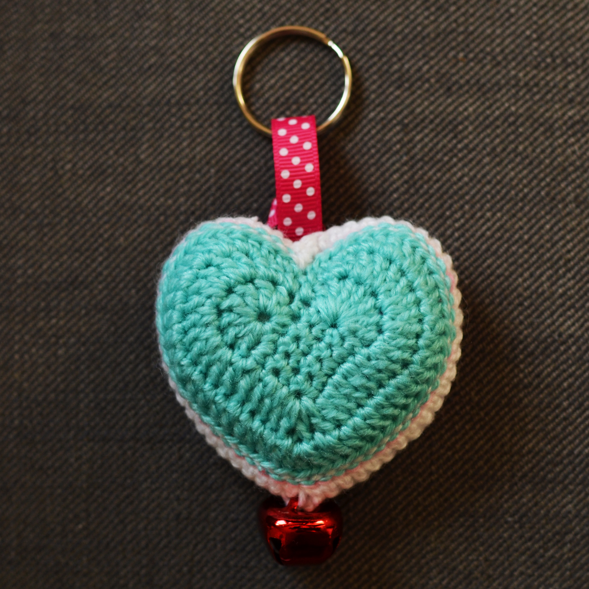 a heart - shaped purse hanging on a metal hook