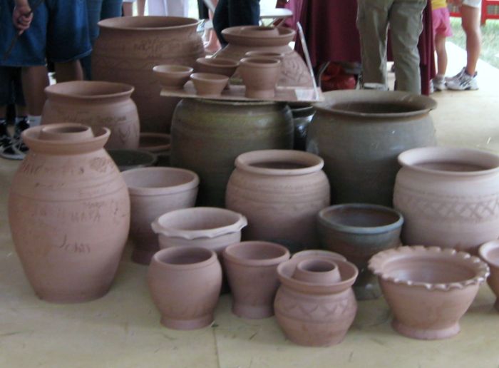 many pottery pots arranged on the floor near each other