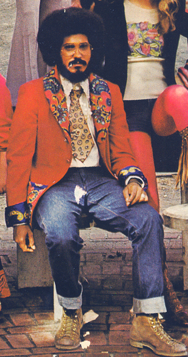 a man sitting on a stool dressed in colorful clothing