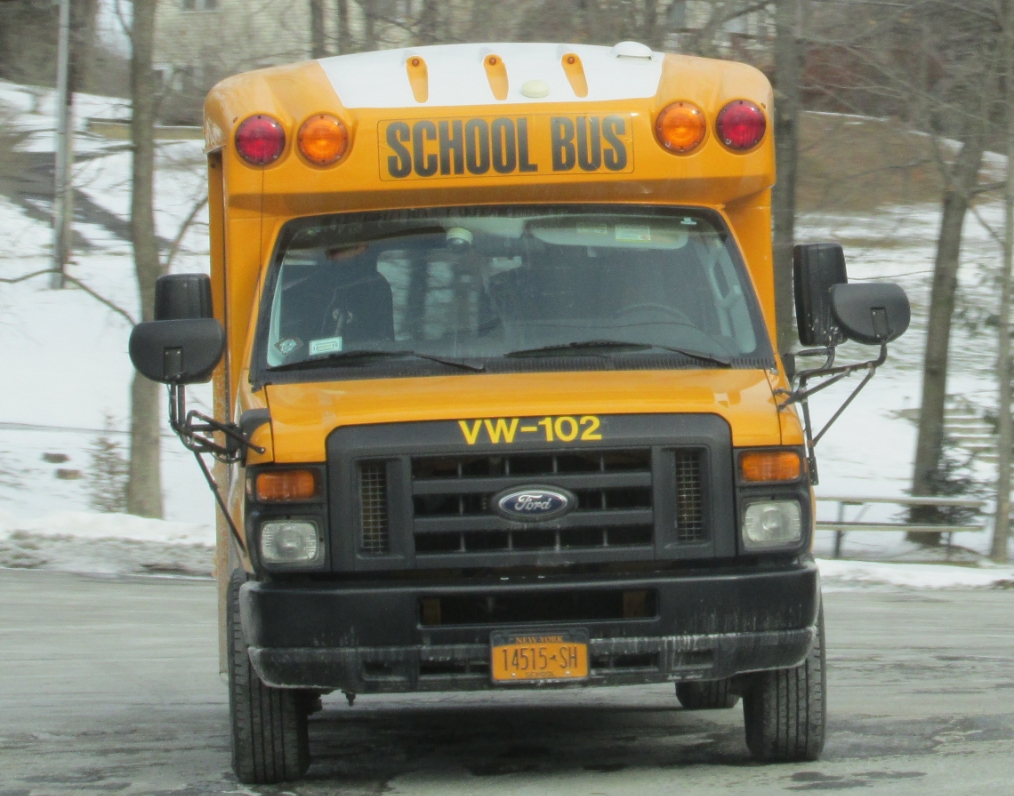 a school bus driving down the road in the snow