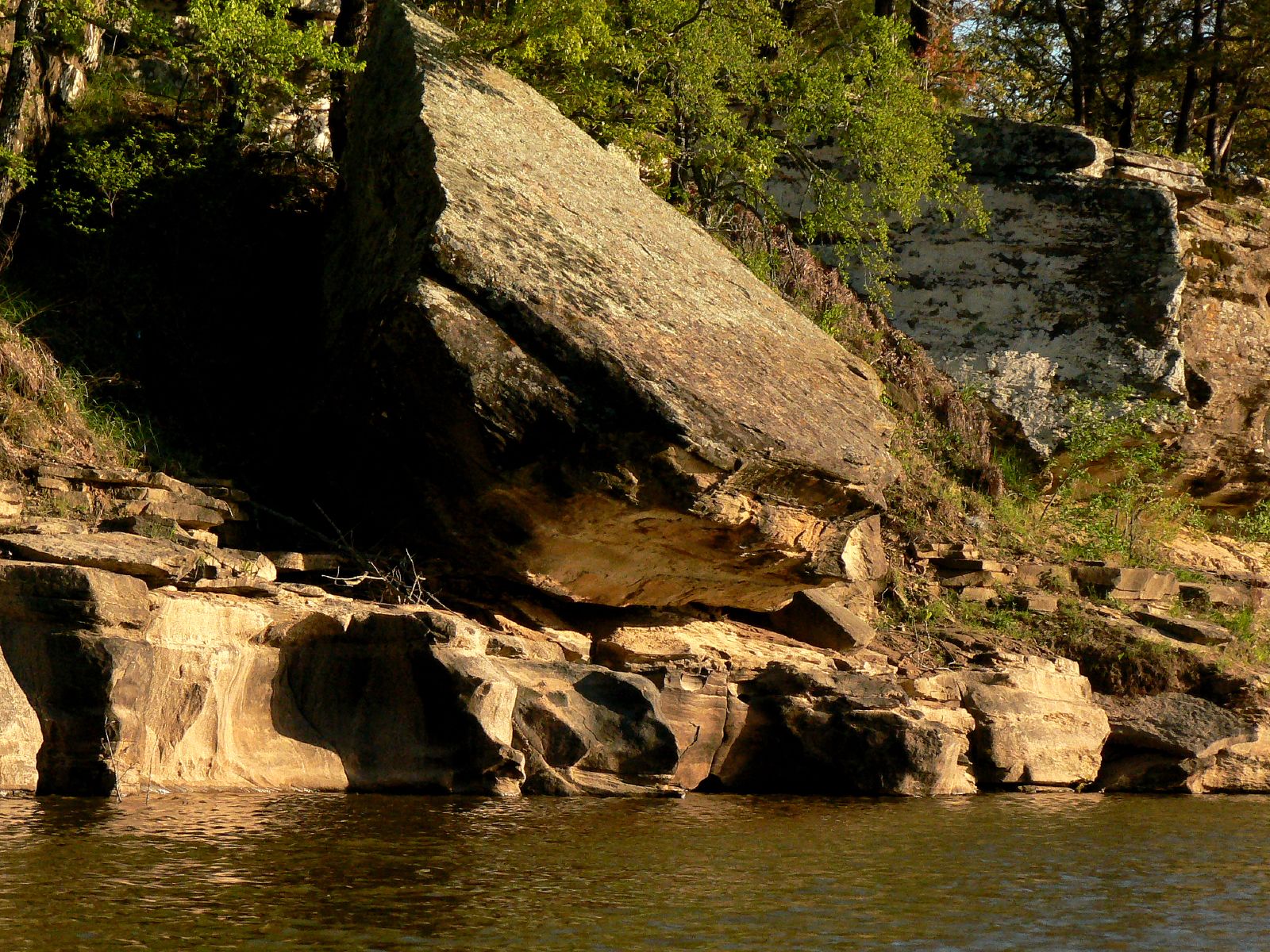 a cliff face sitting on top of a body of water