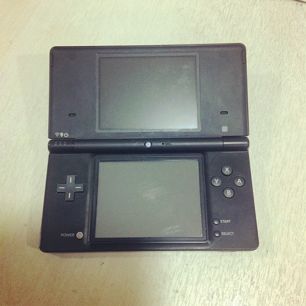 a nintendo ds game system that's turned on with a game pad next to it