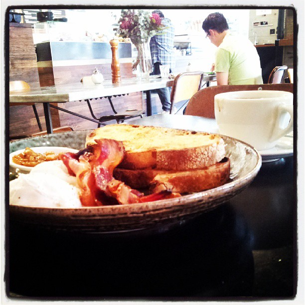 the breakfast food is on a plate near a man at a table