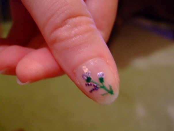 someone with a small flower on their nail
