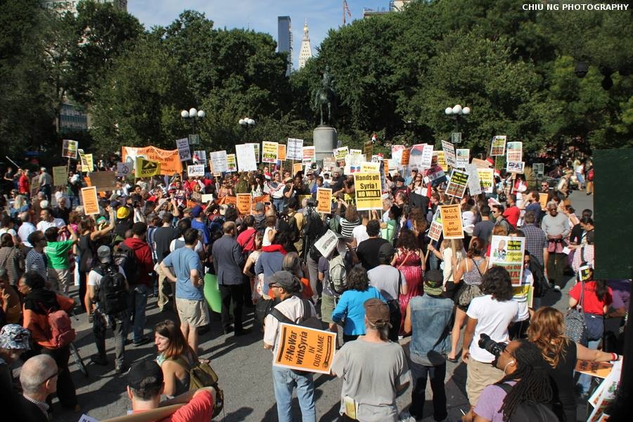 a group of protesters walking together holding up signs