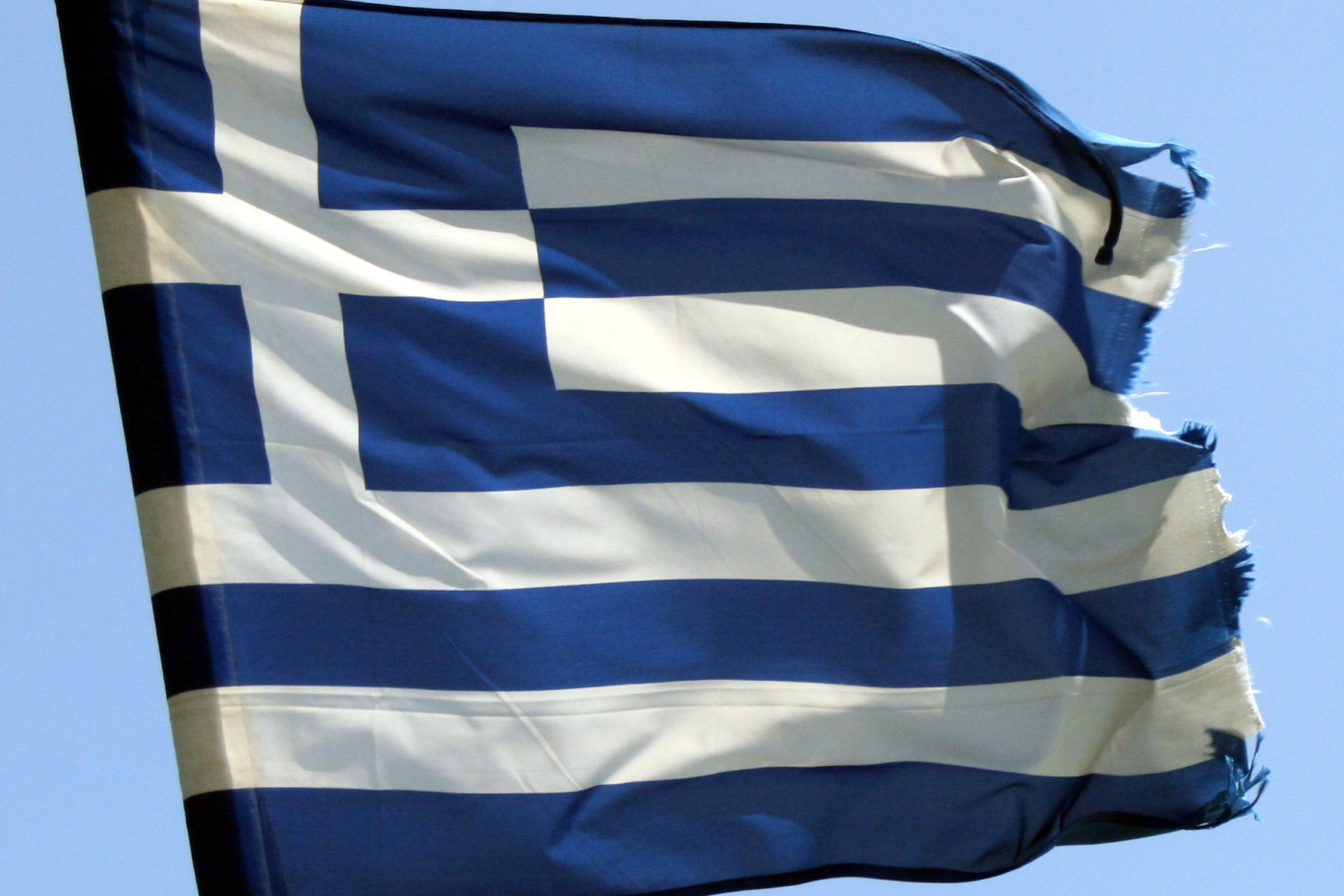 a large flag flying on the wind in the blue sky