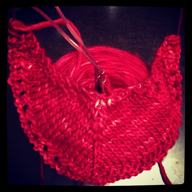 crocheted red knitted piece on table with scissors