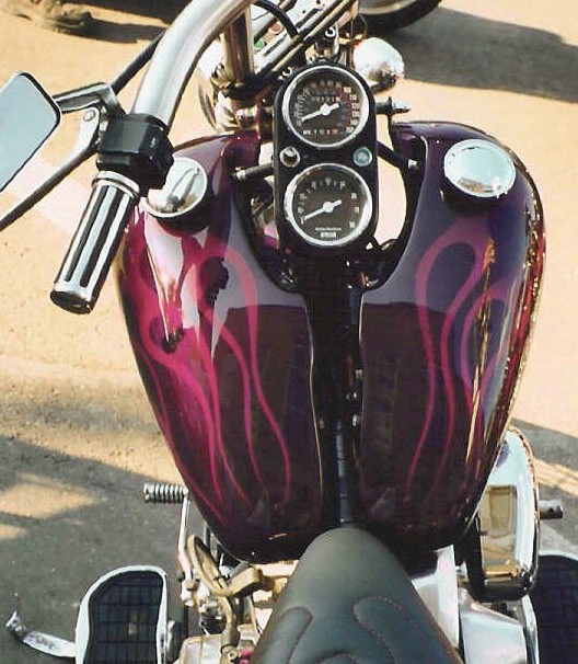 a motorcycle is painted purple and red in the street