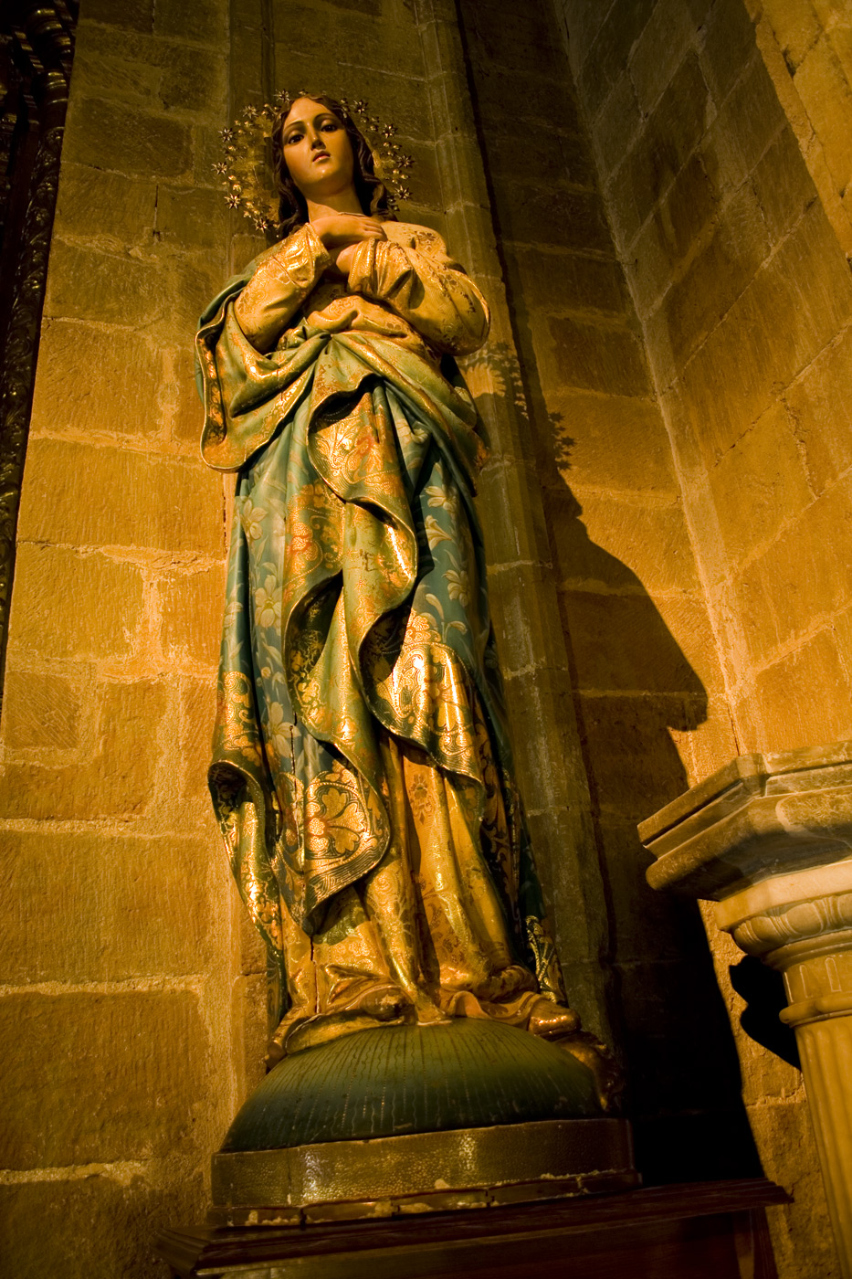 statue of mary with cross on table in large stone