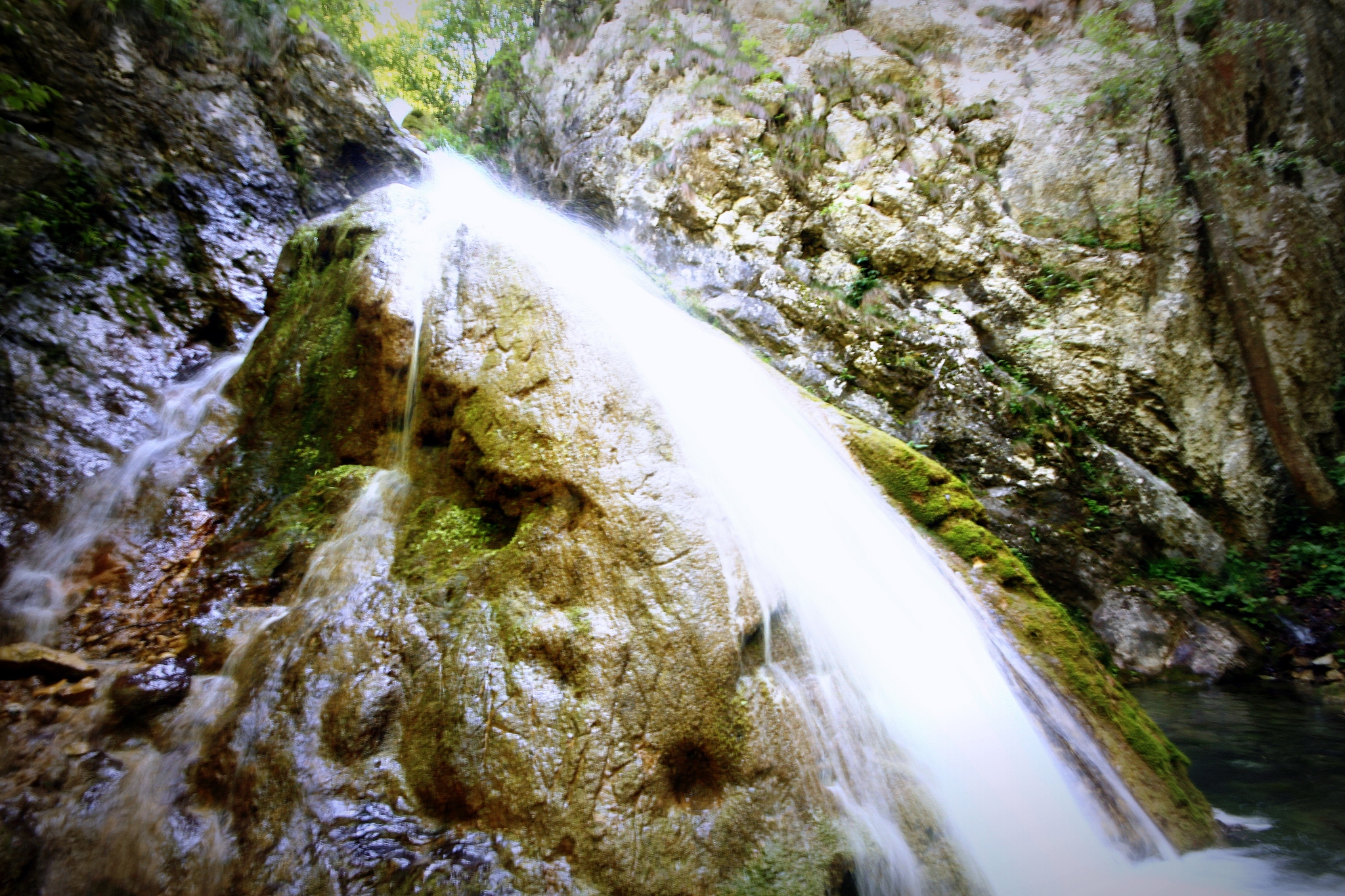 waterfall is being created in a very rocky mountain