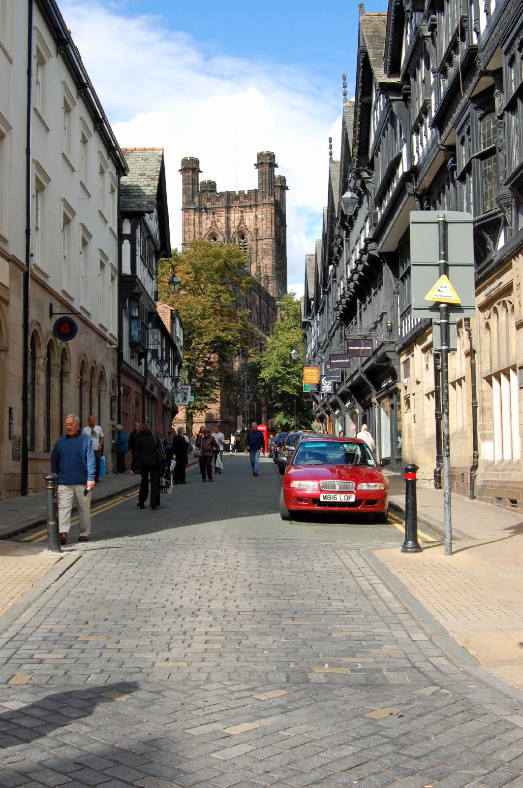a street scene with focus on the red car parked