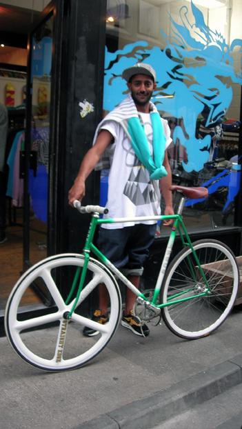 man with bandana standing next to a bicycle