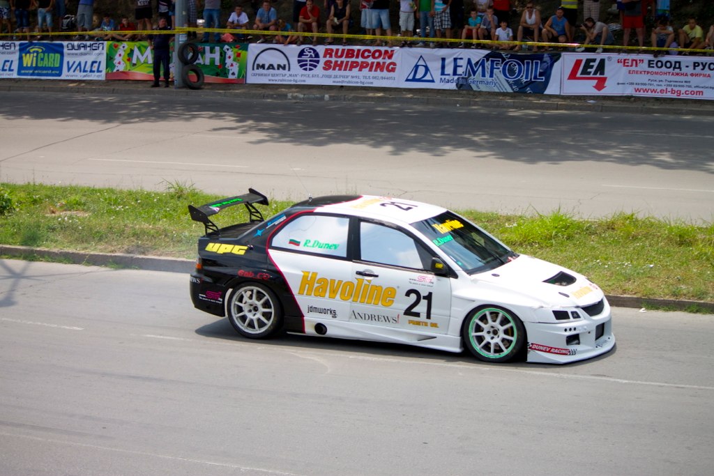 a white car racing down a road with the number 21 on it