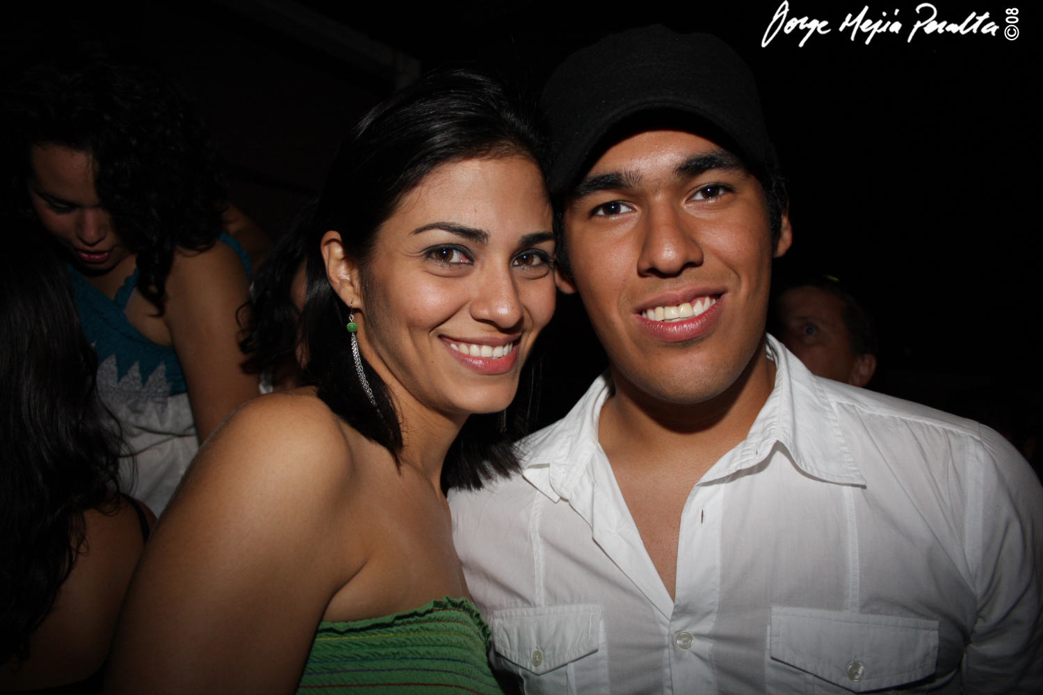 a man and woman smiling for the camera at a party