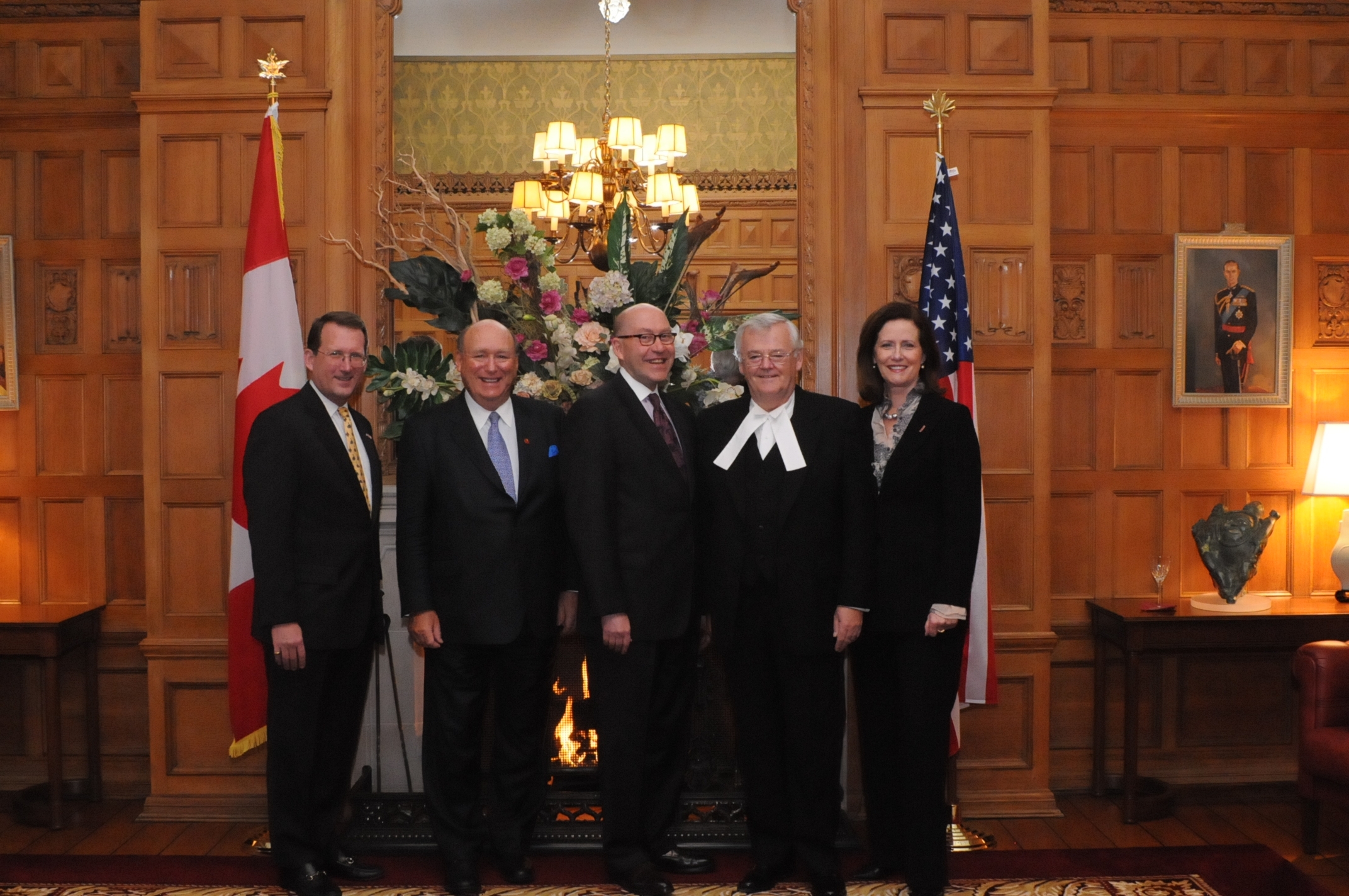 several people are standing in formal clothes in the room