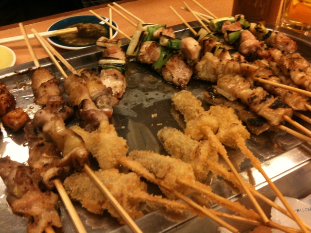 a bunch of skewered food sitting on top of a pan