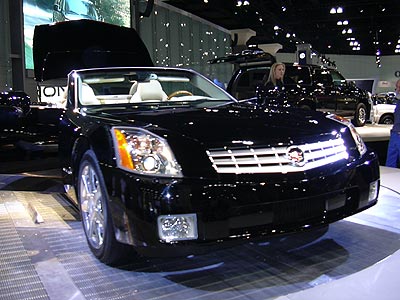 black vehicle is displayed on a show floor