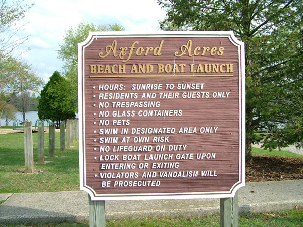a sign on a sidewalk saying the beach and boat launch