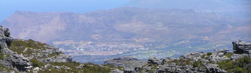 a man on a hill with mountains in the background