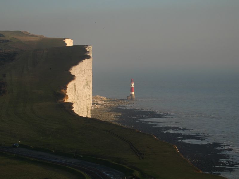 a view of a lighthouse on the coast from behind