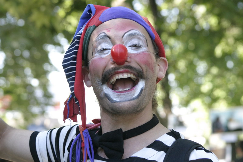 a man wearing clown makeup in a parade