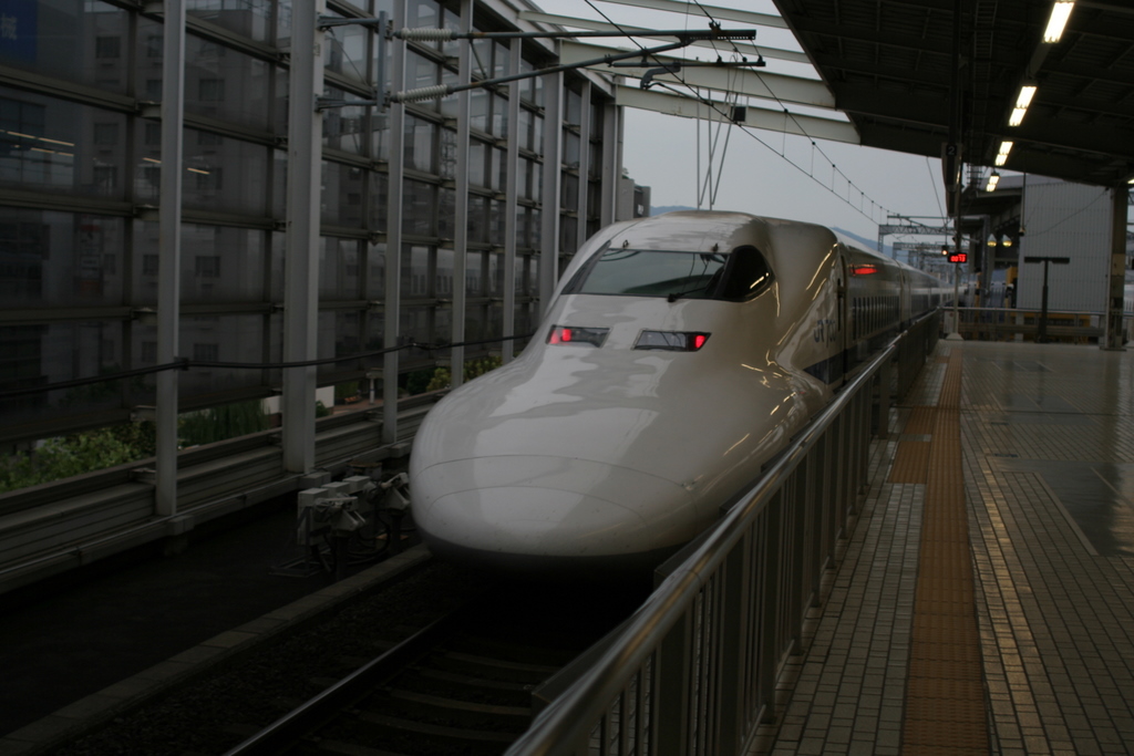 there is a white and black bullet train at the station