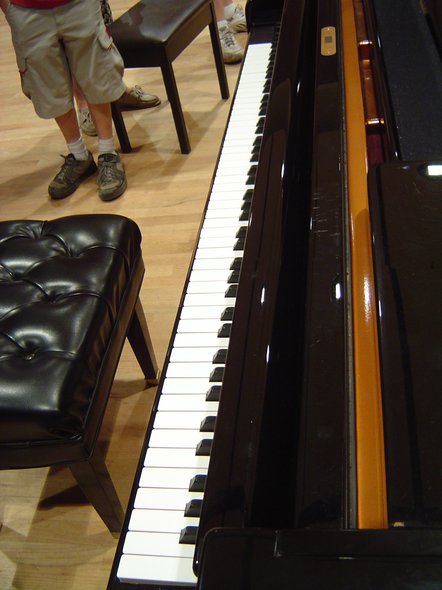 piano sitting on the ground next to a bench with benches