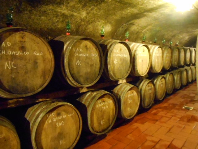 several wine barrels and a brick floor in a wine cellar