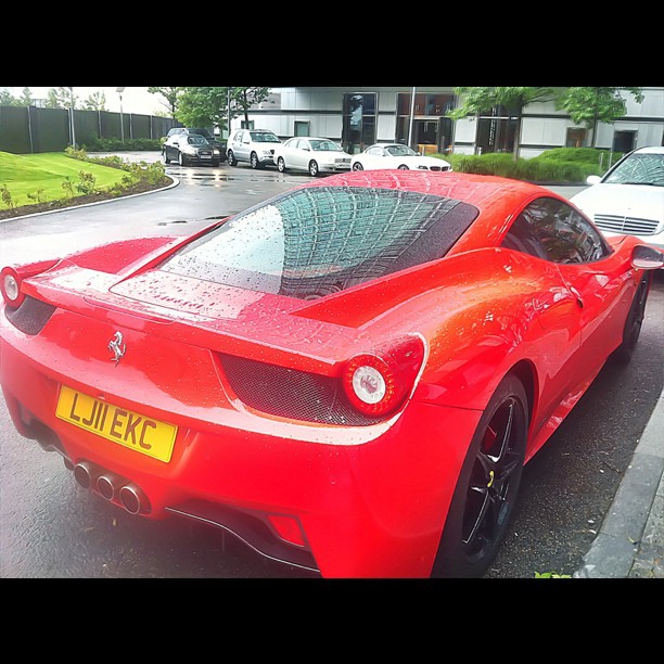 a red sports car is parked in front of a building