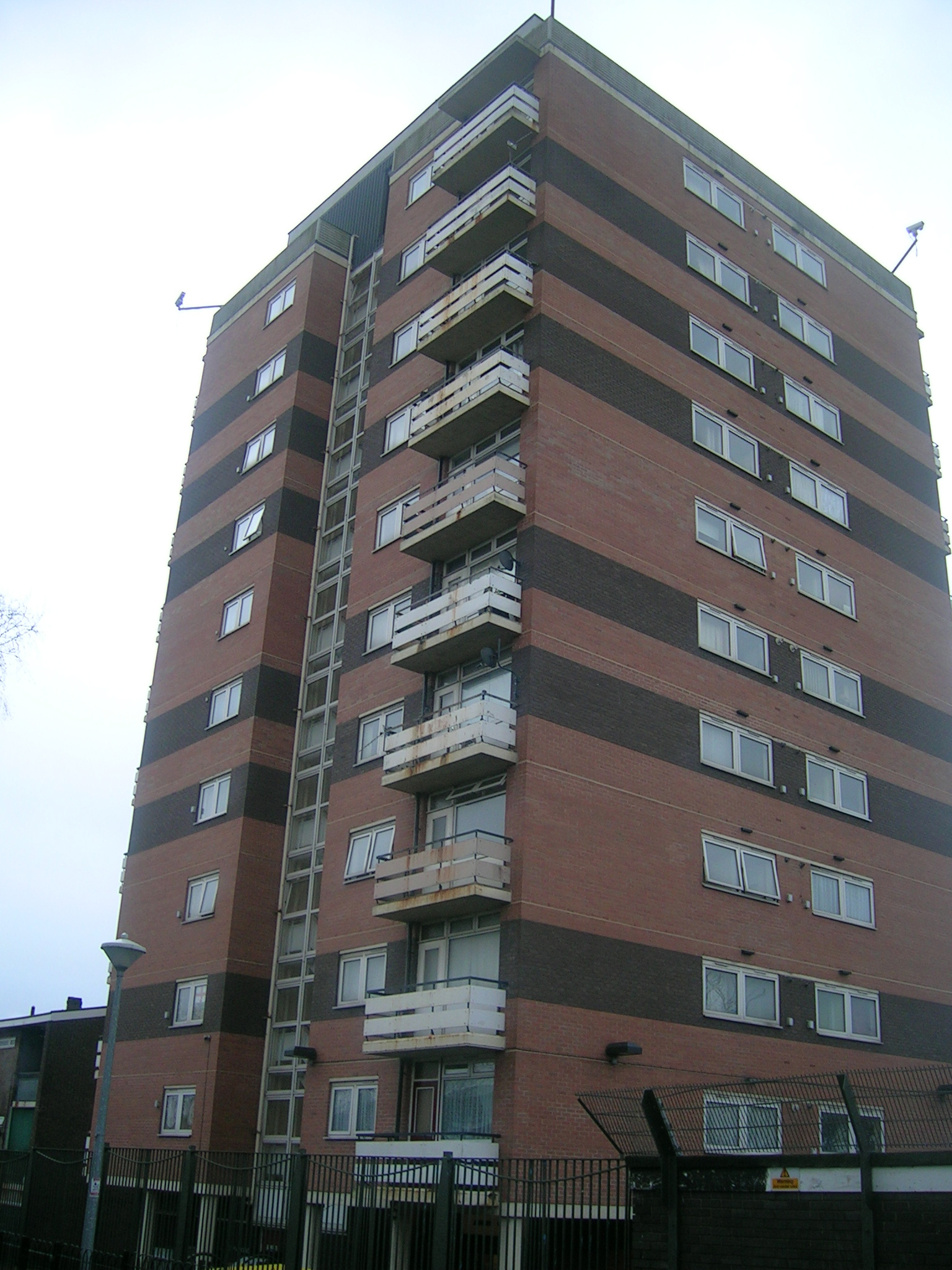 large red brick building with balconies and balconies on the top level