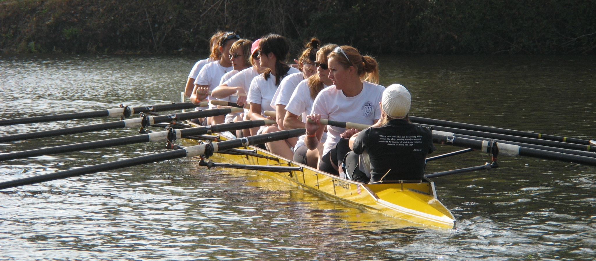 women are rowing a boat across a body of water