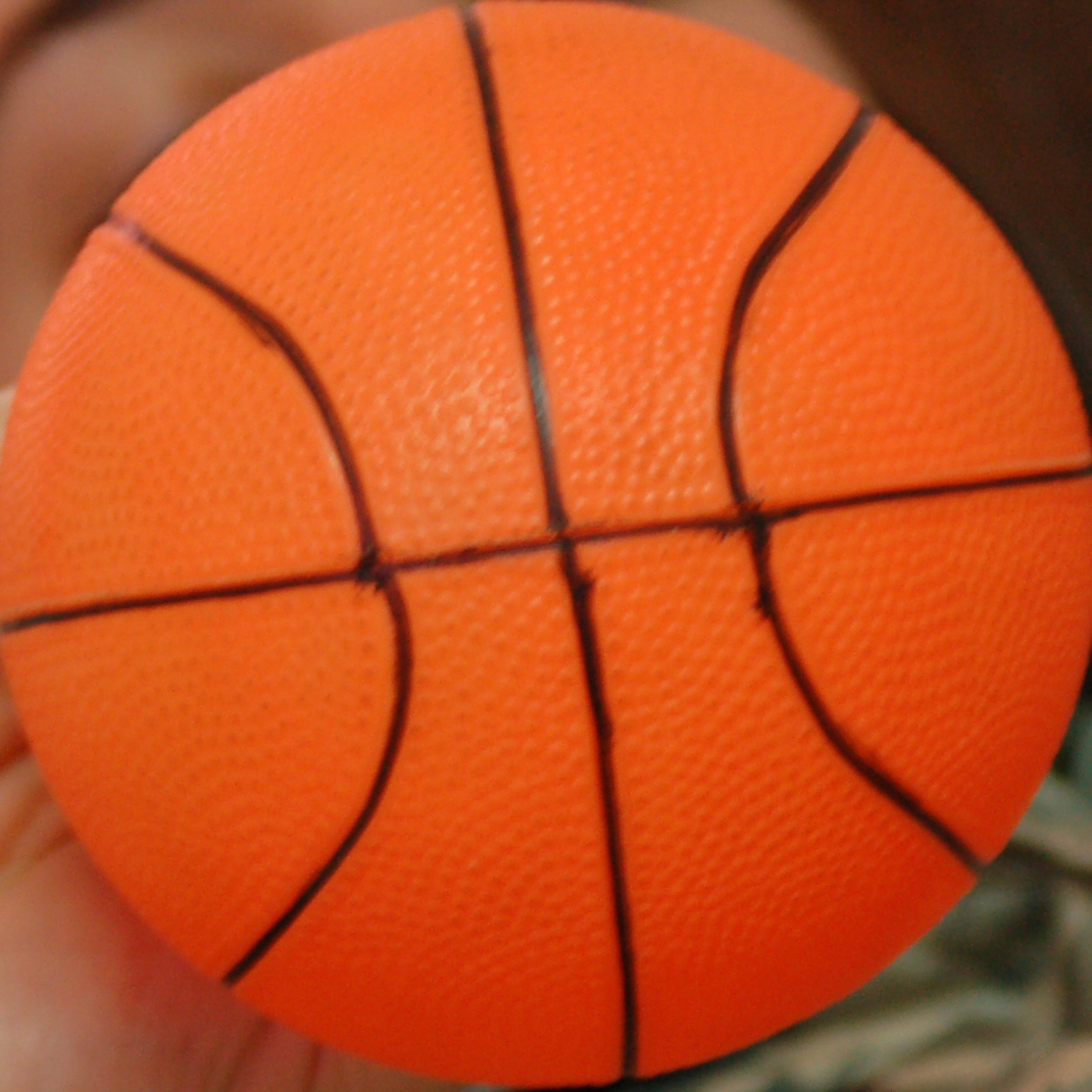 an orange basketball in a persons hand