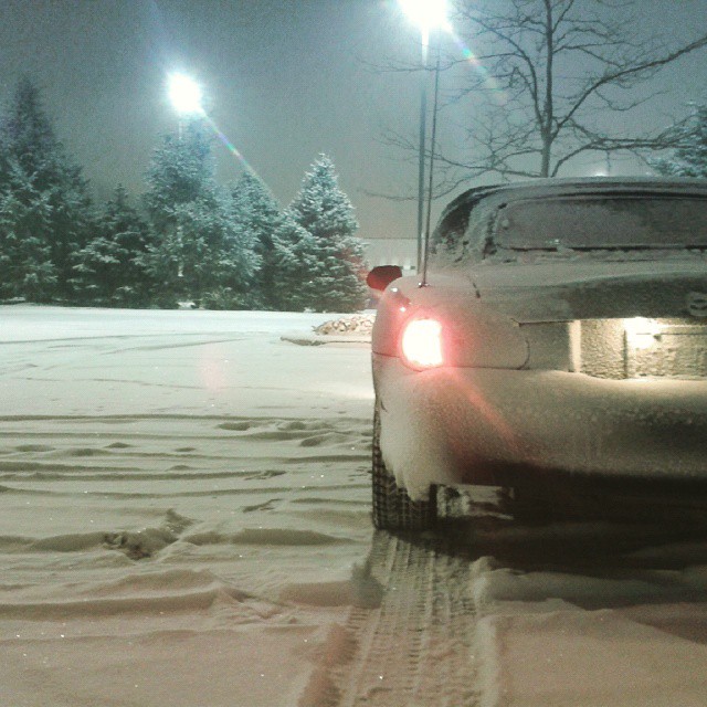 there is snow all over the road and cars parked