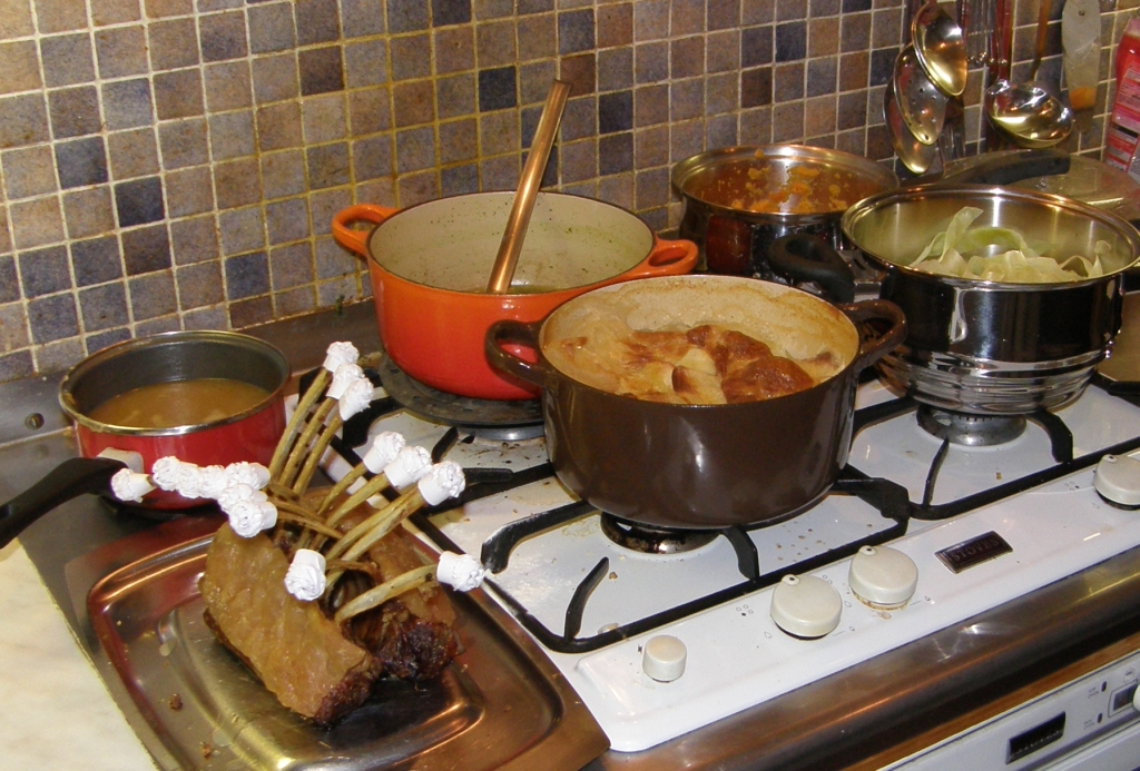 many pots on a stove next to a kettle and pans