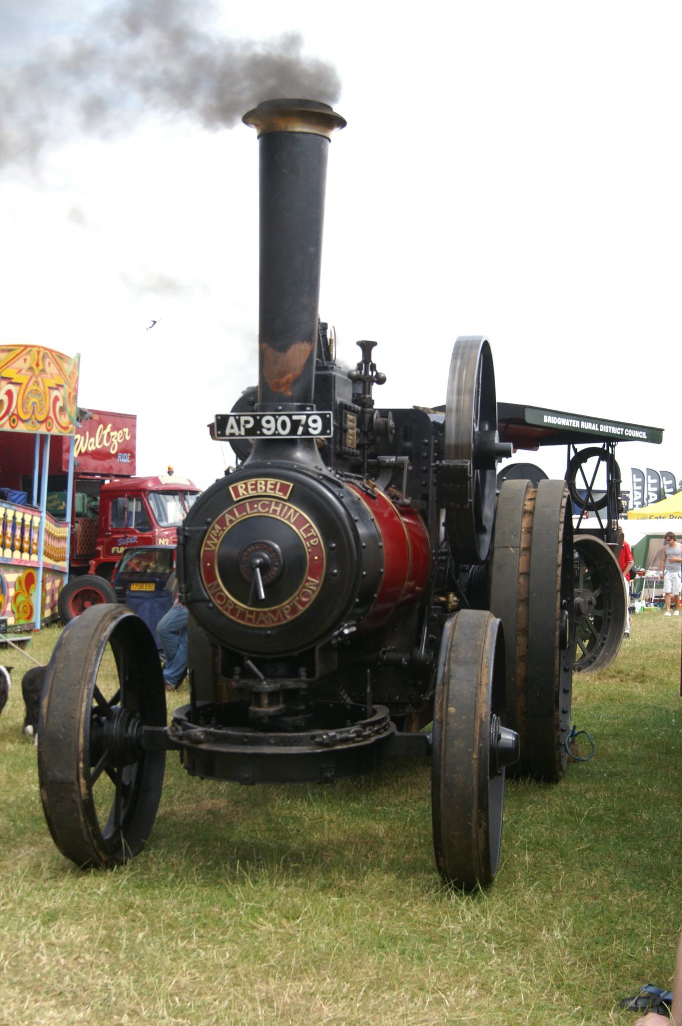 old engine and wheels in open field with booths