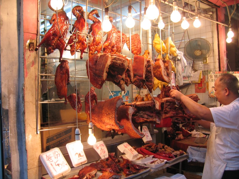 a person hanging up meat in a store