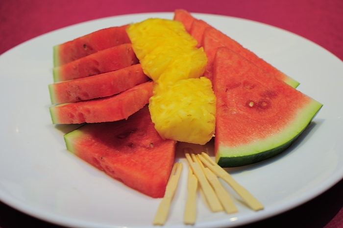 a close up of pieces of watermelon and pineapple on a plate