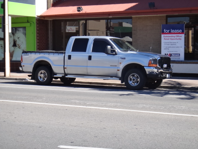 a white pickup truck parked next to a curb