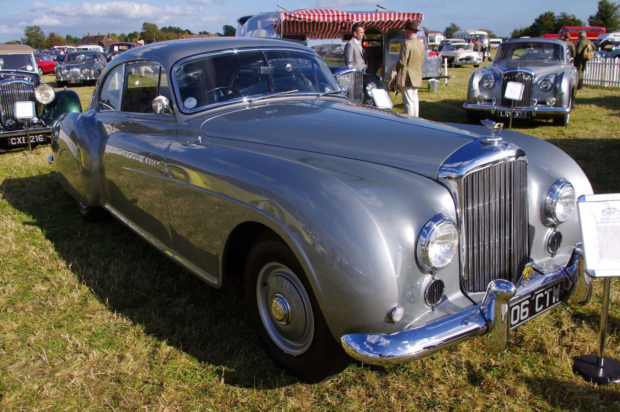 a gray antique sports car at a car show